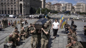 Ukrainian servicemen carry the coffin of British combat medic, volunteer, Peter Fouche, 49 who was killed on June 27 during his work in East Ukraine, at the funeral ceremony on the city's main square in Kyiv, Ukraine, Saturday, July 6, 2024. (AP Photo/Alex Babenko)