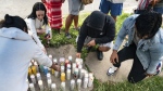 People light candles on the sidewalk during a vigil for 13-year-old Nyah Mway in Utica, N.Y., Saturday, June 29, 2024.  (Daniel DeLoach/Observer-Dispatch via AP)