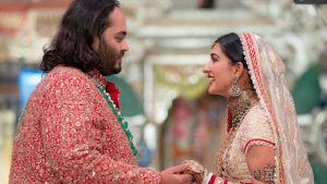 In this photo provided by Reliance Industries, Anant Ambani, left, the son of billionaire Mukesh Ambani, holds hands with Radhika Merchant during their wedding ceremony at Jio World Convention Centre in Mumbai, India, Friday, July 12, 2024. (Reliance Industries via AP) 
