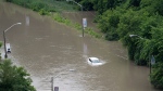 A car is partially submerged in flood waters in the Don Valley following heavy rain in Toronto, on Tuesday, July 16 2024. THE CANADIAN PRESS/Arlyn McAdorey