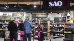 People wait to enter a SAQ outlet in Montreal on Jan. 18, 2022. THE CANADIAN PRESS/Graham Hughes