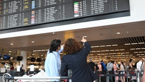 Travelers wait for information in front of a departure board at Brussels International Airport in Brussels, Friday, July 19, 2024.  (AP Photo/Harry Nakos)