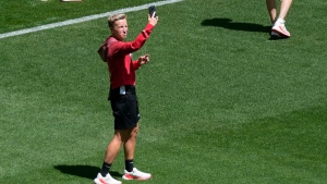 Coach Bev Priestman of Canada takes photos on the pitch at Geoffroy-Guichard Stadium ahead of the 2024 Summer Olympics, Tuesday, July 23, 2024, in Saint-Etienne, France.THE CANADIAN PRESS/AP/Silvia Izquierdo