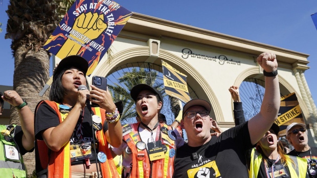  SAG-AFTRA captains Iris Liu, left, and Miki Yamashita, center, and SAG-AFTRA chief negotiator Duncan Crabtree-Ireland lead a cheer for striking actors outside Paramount Pictures studio, Nov. 3, 2023, in Los Angeles. (AP Photo/Chris Pizzello, File)