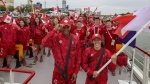 Canada's flag-bearers Maude Charron, right, and Andre de Grasse, left, pose for photos on a boat with their team before the start of the opening ceremony for the 2024 Summer Olympics on the Seine River in Paris, France, Friday, July 26, 2024. THE CANADIAN PRESS/AP-Cao Can/Pool Photo via AP
