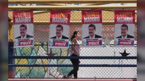 A woman walks on a pedestrian bridge with election signs of Venezuelan President Nicolas Maduro in Caracas, Venezuela, Saturday, July 27, 2024. THE CANADIAN PRESS/AP, Fernando Vergara