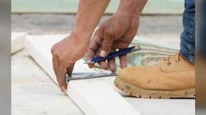 workman measures wood