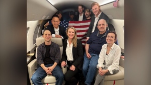 This image released by the White House shows Evan Gershkovich, left, Alsu Kurmasheva, right, and Paul Whelan, second from right, and others aboard a plane, Thursday, Aug. 1, 2024, following their release from Russian captivity. (White House via AP)