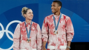 Felix Auger-Aliassime and Gabriela Dabrowski soak in the atmosphere of the crowd as they stand on the podium with their bronze medals in mixed doubles tennis at the Summer Olympics, Friday, August 2, 2024 in Paris. THE CANADIAN PRESS/Adrian Wyld
