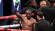 Terence Crawford, center, raises his fist as at the end of the 12 round fight against Israil Madrimov during a super welterweight championship boxing match in Los Angeles, Saturday, Aug. 3, 2024. (AP Photo/Damian Dovarganes)