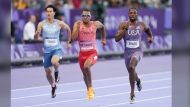 Canada's Andre De Grasse, centre, of Markham, Ont., competes in the men’s 200m qualifying heat at the 2024 Summer Olympics, Monday, Aug. 5, 2024, in Saint-Denis, France. The 29-year-old crossed the finish line in 20.30 seconds to finish second in Heat 6. THE CANADIAN PRESS/Christinne Muschi