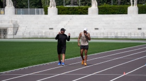 FILE - Defending Olympic 100 meters champion Marcell Jacobs, right, talks with his coach Rana Reider during a training session in the historic Stadio dei Marmi ahead of an athletics meeting in Rome, Wednesday, May 15, 2024. (AP Photo/Alessandra Tarantino, file)