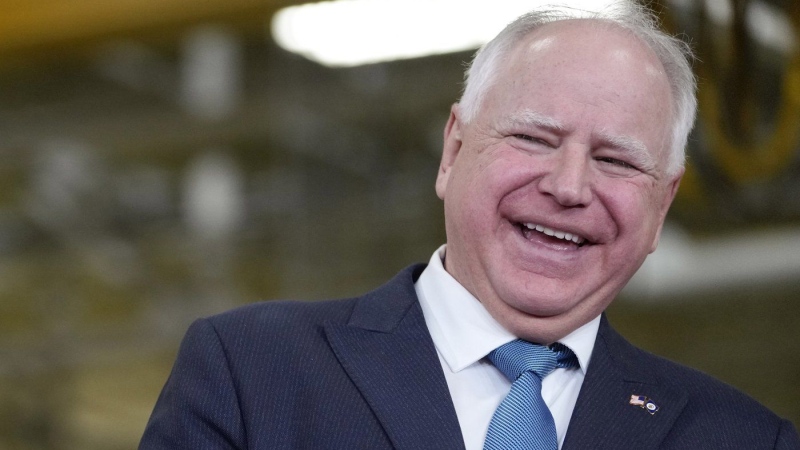 Minnesota Gov. Tim Walz, right, laughs as he stands with Fridley, Minn., Mayor Scott Lund during a visit to the Cummins Power Generation Facility in Fridley, Minn., Monday, April 3, 2023. (AP Photo/Carolyn Kaster, File)