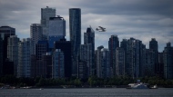 A Harbour Air seaplane takes off past office and condo towers as a boat refuels at a floating Chevron station on the water, in Vancouver, on July 25. THE CANADIAN PRESS/Darryl Dyck