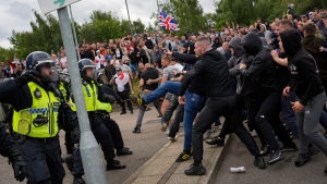 Trouble flares during an anti-immigration protest outside the Holiday Inn Express in Rotherham, England, Sunday Aug. 4, 2024. (Danny Lawson/PA via AP)