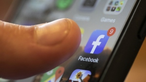 An iPhone displays the Facebook app, Aug. 11, 2019, in New Orleans. (AP Photo/Jenny Kane, File)