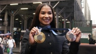 Two-time U.S. Olympic gymnast medalist Jordan Chiles shows her medals after ringing the closing bell at the Nasdaq MarketSite, in New York's Times Square, Thursday, Aug. 8, 2024. (AP Photo/Richard Drew)