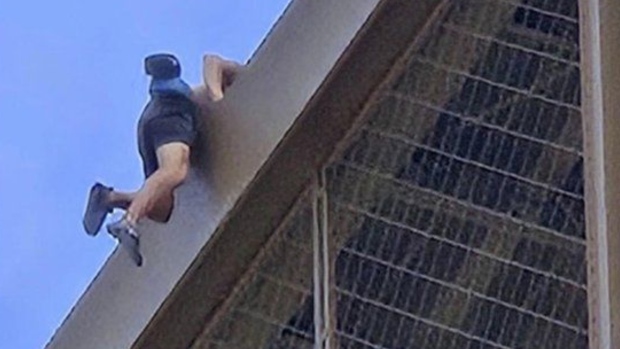 Shirtless man climbing Eiffel Tower