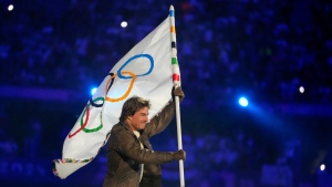 Tom Cruise carries the Olympic flag during the 2024 Summer Olympics closing ceremony at the Stade de France, Sunday, Aug. 11, 2024, in Saint-Denis, France. (AP Photo/Natacha Pisarenko)