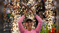 Pyrotechnics fire behind Jessica Pegula, of the United States, as she raises her trophy following her women's singles win at the National Bank Open, in Toronto, Monday, Aug. 12, 2024. THE CANADIAN PRESS/Frank Gunn