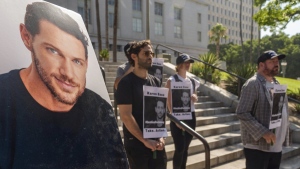 Friends and supporters of late actor Johnny Wactor, pictured left, hold a news conference to demand justice for the former "General Hospital" actor during a news conference outside Los Angeles City Hall in Los Angeles Tuesday, Aug.13, 2024. (AP Photo/Damian Dovarganes)