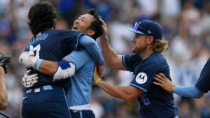 Chicago Cubs' Seiya Suzuki, center, celebrates with teammates Dansby Swanson, left, and Patrick Wisdom, right, after hitting a walkoff single to defeat the Toronto Blue Jays in a baseball game in Chicago, Friday, Aug. 16, 2024. (AP Photo/Paul Beaty)