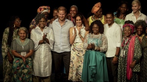 Prince Harry and his wife Meghan pose for a group photo after a forum on Afro women and power in Cali, Colombia, Sunday, Aug. 18, 2024. (AP Photo/Ivan Valencia)