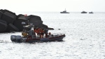 Italian firefighters scuba divers direct towards rescue teams who returned to the site of a storm-sunken superyacht to search for six people, including British tech magnate Mike Lynch, who are believed to be still trapped in the hull 50 metres underwater, in Porticello, southern Italy, Tuesday, Aug. 20, 2024. (AP Photo/Salvatore Cavalli)