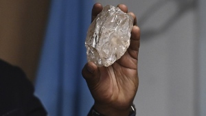 A person holds a 2,492-carat diamond which was found in the country and on show, in Gaborone, Botswana, Thursday, Aug. 22, 2024. (AP Photo)