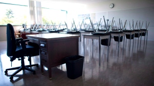 An empty teacher's desk is pictured at the front of an empty classroom on Sept. 5, 2014. (THE CANADIAN PRESS/Jonathan Hayward)