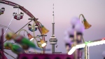 The CN Tower is shown in the background of rides at the Canadian National Exhibition (CNE) in Toronto, Thursday, Aug. 29, 2024. THE CANADIAN PRESS/Paige Taylor White