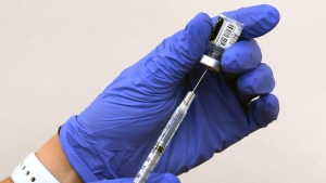 A health-care professional draws COVID-19 vaccine from a small vial. (Joe Burbank / Orlando Sentinel via AP)