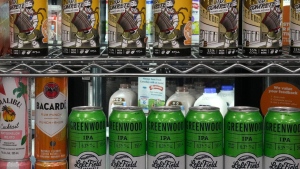 Beer cans are stacked in front a display of milk at a convenience store in Toronto, Thursday, Dec. 14, 2023. THE CANADIAN PRESS/Chris Young