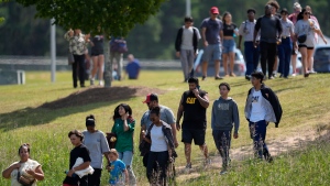 Students and parents walk off campus at Apalachee High School, Sept. 4, 2024, in Winder, Ga. (AP Photo/Mike Stewart)