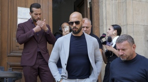 Andrew Tate, center, and his brother Tristan, left, walk outside the Court of Appeals building, after a hearing, in Bucharest, Romania, Wednesday, Sept. 4, 2024. (AP Photo/Vadim Ghirda)