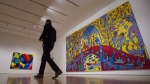 A reporter walks past 'Androgyny' by Norval Morrisseau (right) during a media tour of the Canadian and Indigenous Art: 1968 to Present at the National Gallery of Canada's contemporary art galleries on May 2, 2017 in Ottawa. THE CANADIAN PRESS/Adrian Wyld