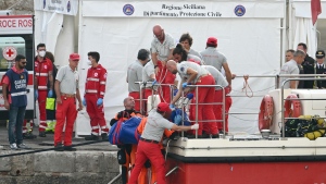 Rescuers carry a body after divers return to Porticello harbor near Palermo, three days after the British-flagged luxury yacht Bayesian sank. (Alberto Pizzoli/AFP/Getty Images via CNN Newsource)