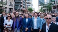 Rob Baker and Mike Downie, stand with family and friends, and those involved with the band's latest documentary at the public sing-along with Choir! Choir! Choir! dedicated to the The Tragically Hip at the Toronto International Film Festival, in Toronto, on Thursday Sept. 5, 2024. THE CANADIAN PRESS/Paige Taylor White