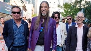 The Tragically Hip band members, from left, Gord Sinclair, Rob Baker, Paul Langlois (light jacket) and Johnny Fay, far right, walk from the premiere of a documentary film about them, "The Tragically Hip: No Dress Rehearsal," to a fan sing-along during the Toronto International Film Festival, Thursday, Sept. 5, 2024, in Toronto. (AP Photo/Chris Pizzello)