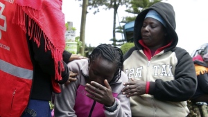 Kenya Red Cross personnel and relatives try to comfort a woman reacting near a burned-out dormitory, following a fire at the Hillside Endarasha Primary in Nyeri, Kenya Friday, Sep. 6, 2024. (AP Photo)