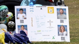 A poster with images of victims is displayed at a memorial outside Apalachee High School, Friday, Sept. 6, 2024, in Winder, Ga., following a shooting at the school earlier in the week. (Arvin Temkar/Atlanta Journal-Constitution via AP)