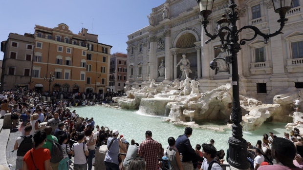 FILE - Tourists admire the Trevi Fountain in Rome, June 7, 2017. (AP Photo/Gregorio Borgia, File)