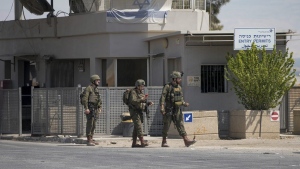 Israeli soldiers stand guard near the site of a deadly shooting attack where Israeli officials say three people were shot and killed at the Allenby Bridge Crossing between the West Bank and Jordan, Sunday, Sept. 8, 2024. (AP Photo/Mahmoud Illean)