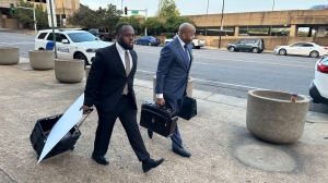 Former Memphis police officer Tadarrius Bean, left, and his lawyer John Keith Perry walk towards the entrance of a federal courthouse before the start of jury selection of the trial in the Tyre Nichols case on Monday, Sept. 9, 2024, in Memphis, Tenn. (AP Photo/Adrian Sainz)