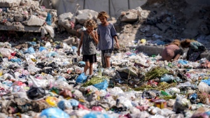 Displaced children sort through trash at a street in Deir Al-Balah, central Gaza Strip, on August 29. (Abdel Kareem Hana/AP via CNN Newsource)

