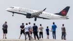 Air Canada is preparing for a potential shutdown of most operations next week as contract talks with its pilots' union near an impasse. People look on as an Air Canada plane takes off at Pierre Elliott Trudeau International Airport in Montreal, Sunday, June 11, 2023. THE CANADIAN PRESS/Graham Hughes