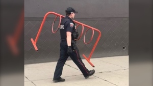 Hamilton police are seen seizing a stolen bike rack from a downtown encampment. (Hamilton Police Service)