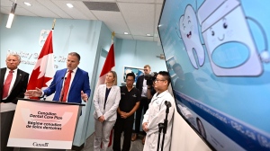 Health Minister Mark Holland says his government will still work on policies it promised to pursue under its now-defunct deal with the NDP. An illustration of a tooth is seen on a screen in a dental office as Holland makes an announcement on the Canadian Dental Care Plan in Ottawa, on Wednesday, Aug. 7, 2024. THE CANADIAN PRESS/Justin Tang