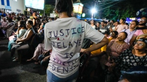 A girl wearing a T-shirt inscribed "justice delayed is justice denied" during a midnight rally to protest against the rape and murder of a resident doctor at a government hospital in early August, in Kolkata, India, Sept. 8, 2024. (AP Photo/Bikas Das)