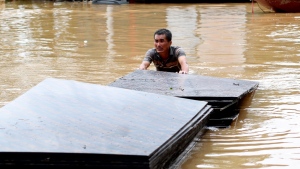 A man pushes a stack of plyboards in flood following Typhoon Yagi in Hanoi, Vietnam on Tuesday, Sept. 10, 2024. (AP Photo/Huy Han)
